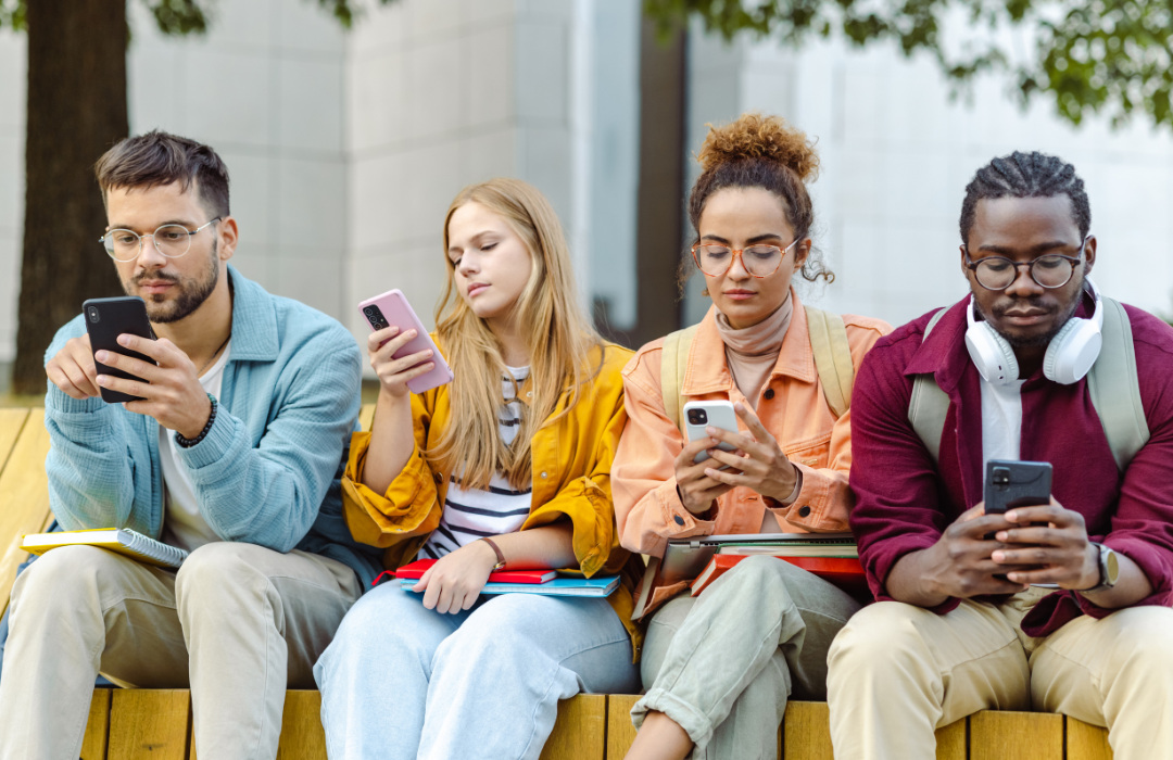 An image of four people using their phones.
